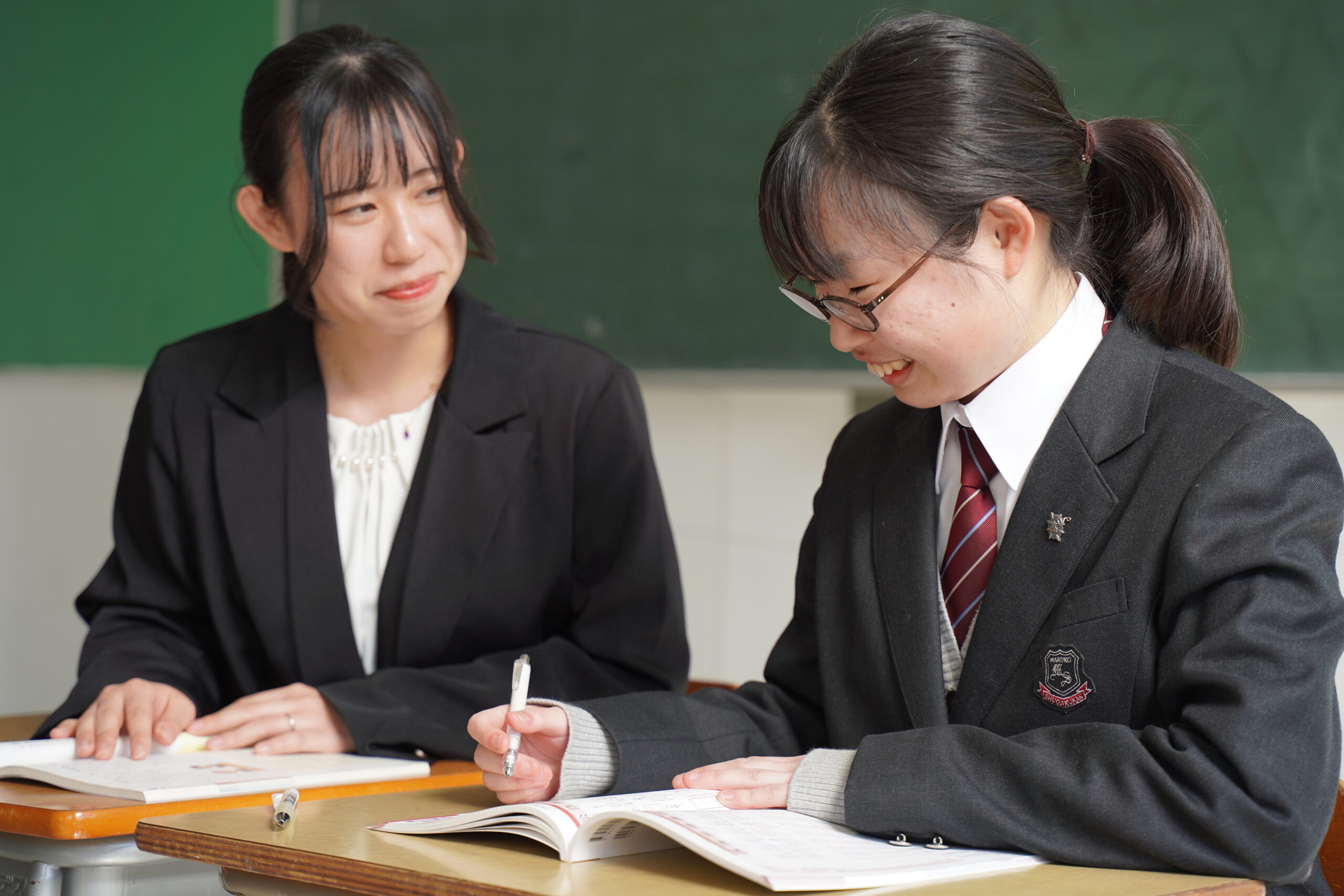 先生に教えてもらっている女子生徒